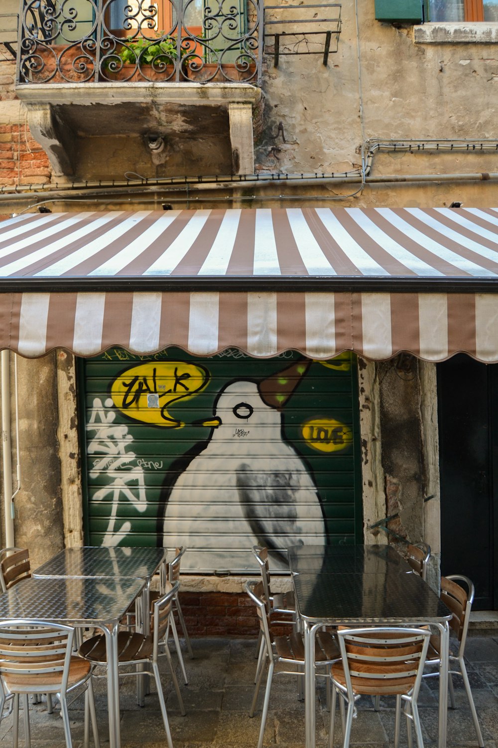 white and black bird wearing brown hat graffiti on roller shutter