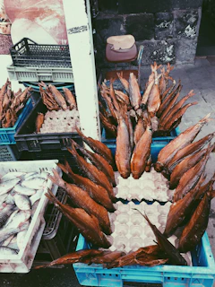 A smiling staff member carefully packaging smoked fish for online orders.