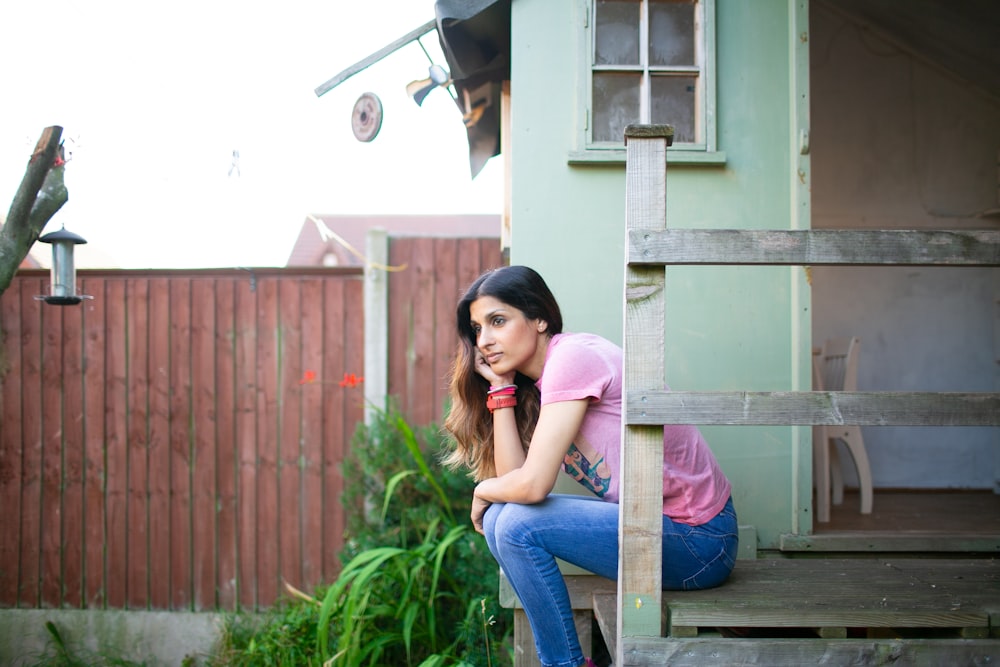 woman sitting beside green wall