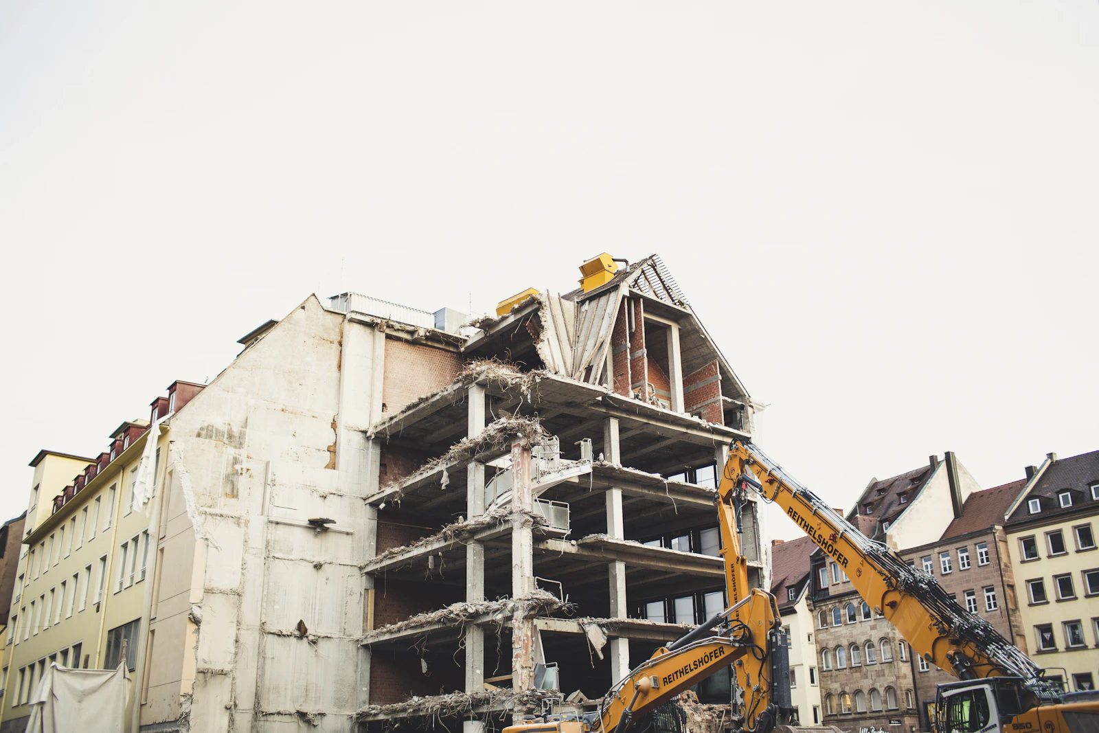 Licensed demolition crew operating heavy machinery on a multi-storey demolition project