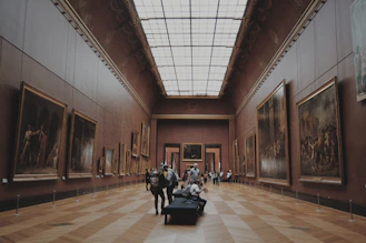 people walking on corridor looking at painting