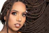 Close-up of a smiling woman with beautifully braided hair styled by p’s luxe glamor.
