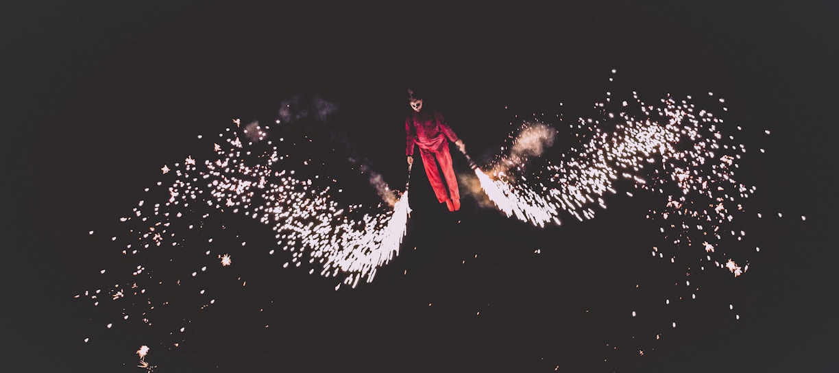 person wearing red jacket and pants playing fireworks