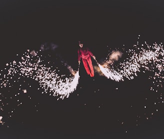 person wearing red jacket and pants playing fireworks