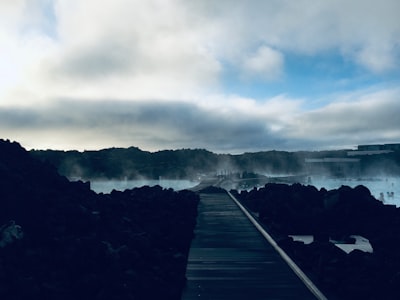 brown wooden dock near body of water hot spring teams background