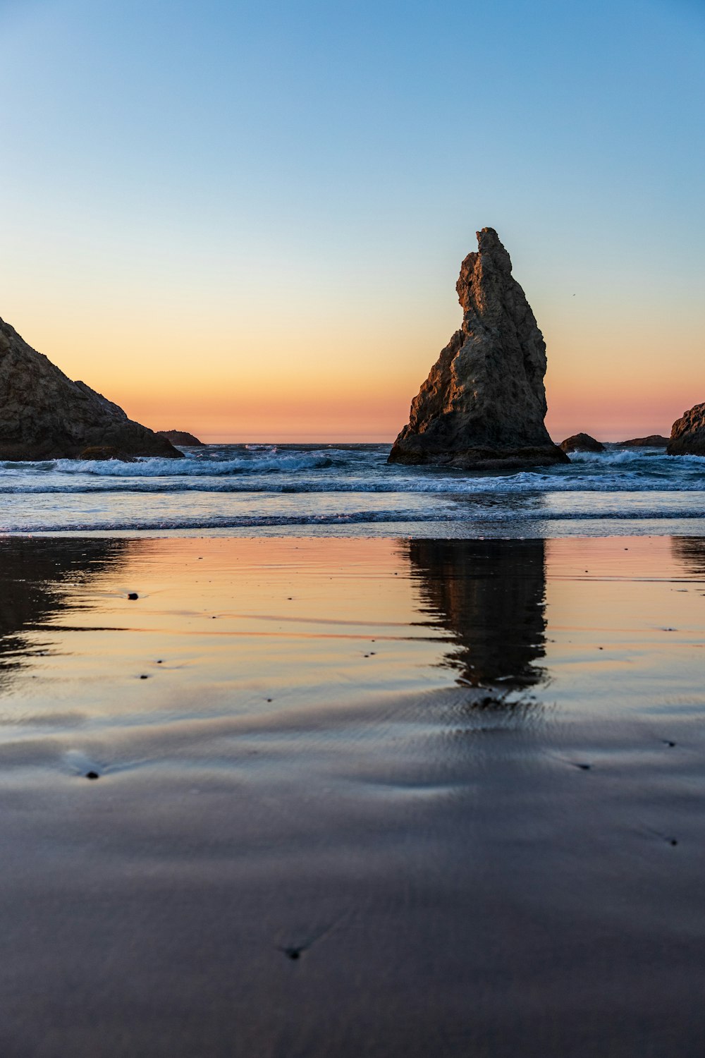 rock formation on the body of water photograph