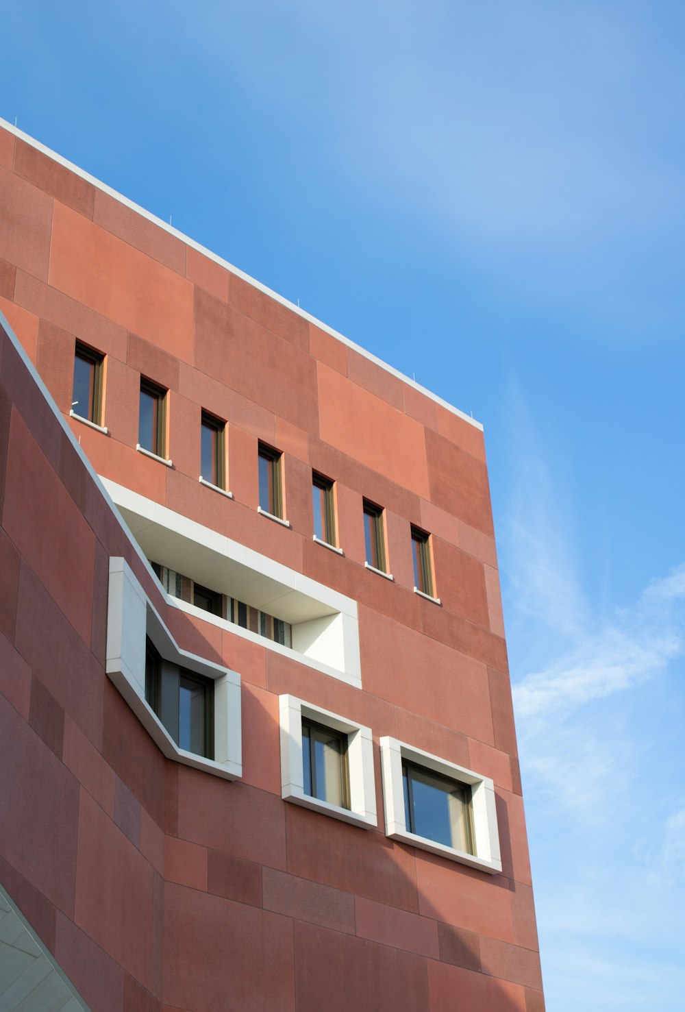 low-angle photography of red concrete building under blue sky