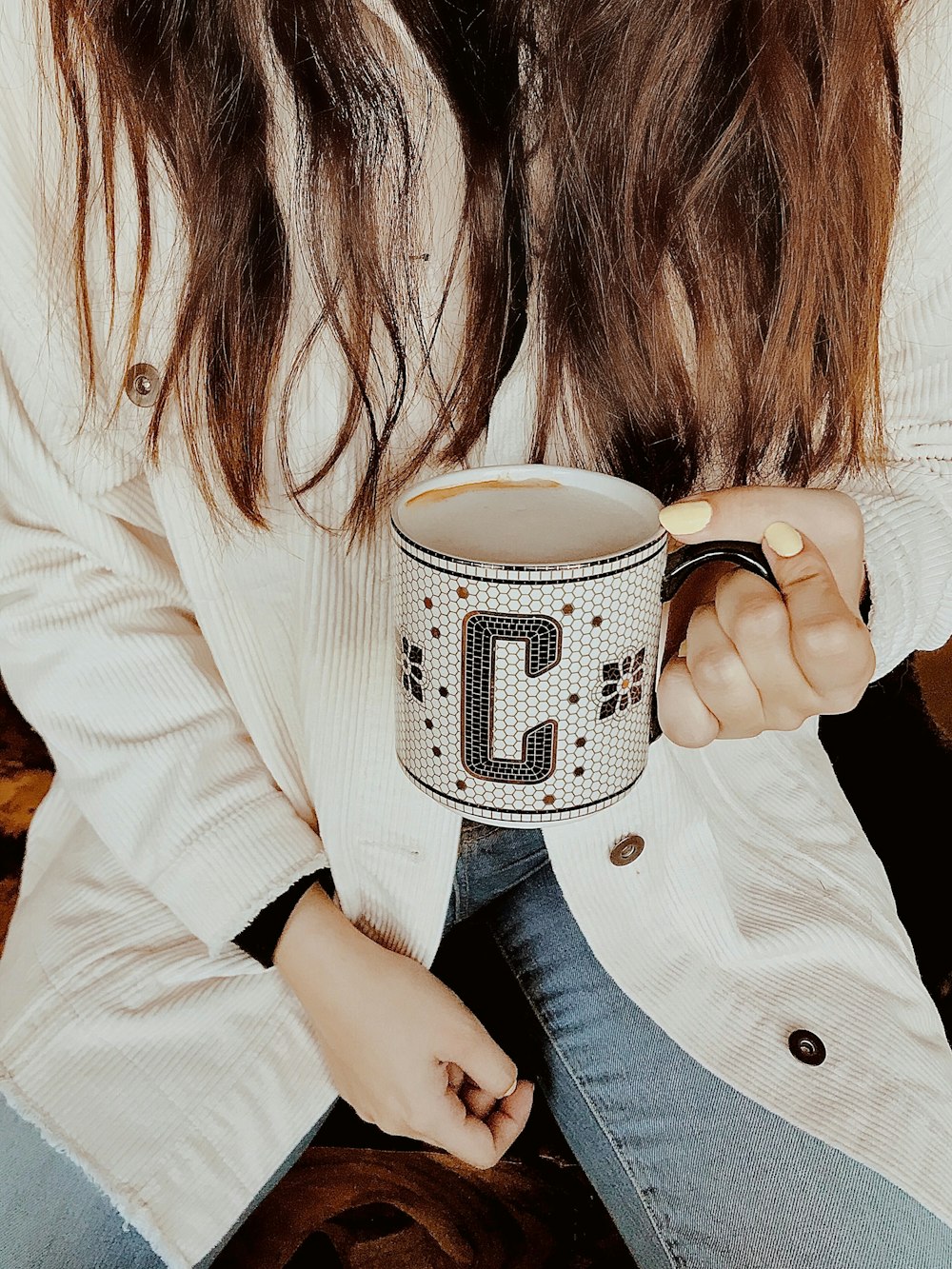 woman holding white and gray ceramic mug