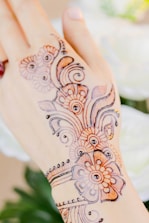 Close-up of intricate mehndi designs glowing under soft golden light.
