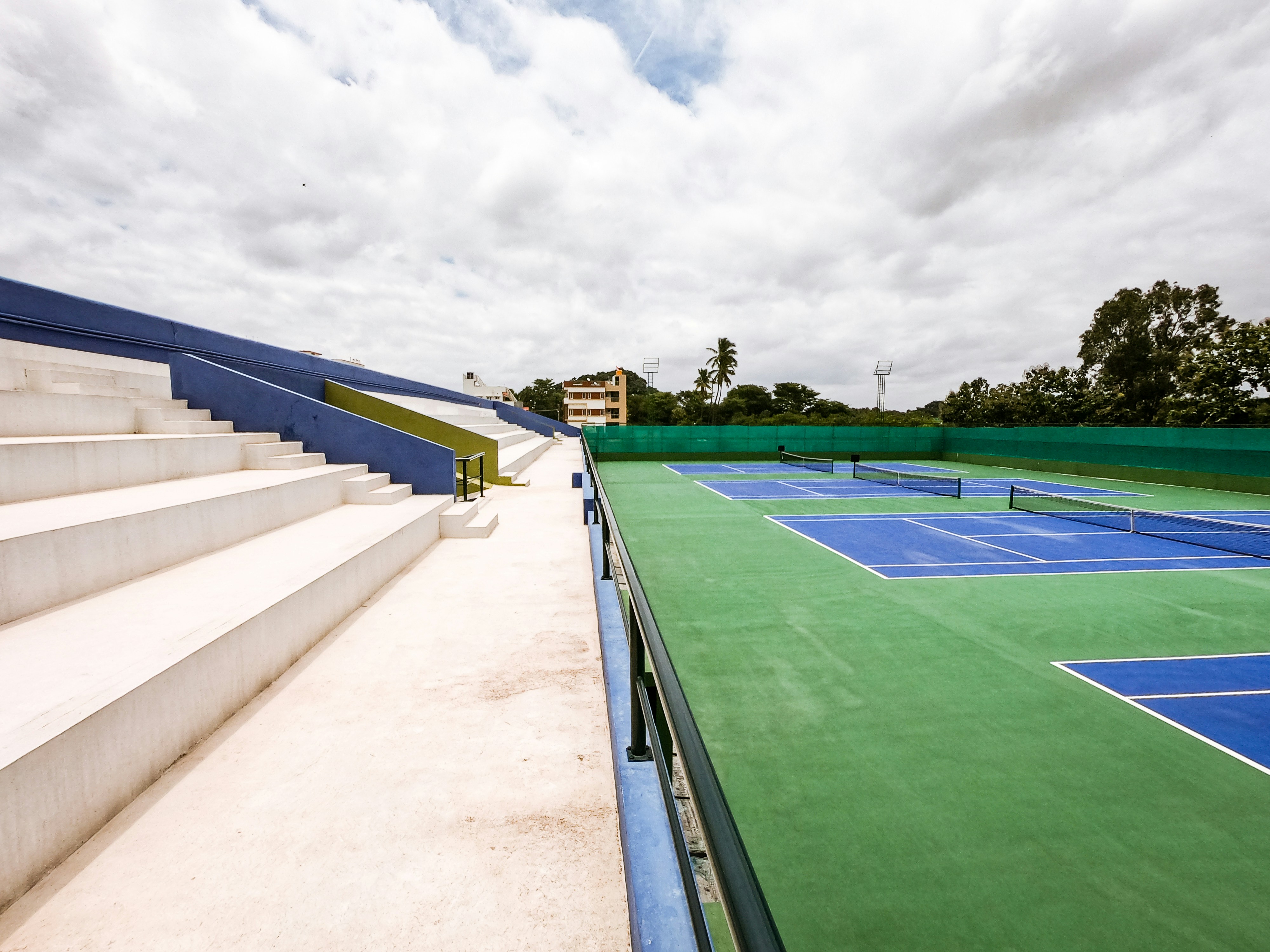 green and blue sports field under white sky during daytime