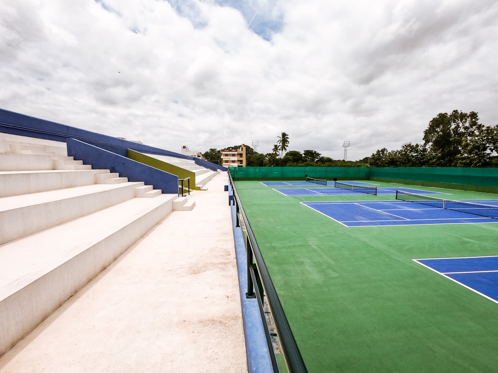 green and blue sports field under white sky during daytime