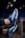 A pair of athletic shoes with a vibrant blue and black design, highlighted by prominent air cushions and sleek lines. The shoes feature a modern and stylish appearance with intricate detailing on the sides and soles.
