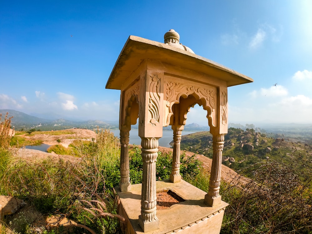 brown wooden gazebo viewing mountain and blue sea under blue and white sky during daytime