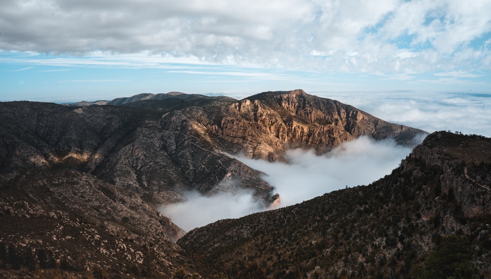 aerial photo of mountains under cloudy sky