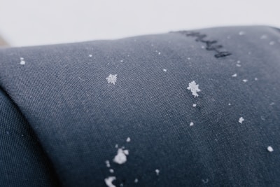 Close-up image of waterproof ski jacket fabric with snowflakes on the surface.