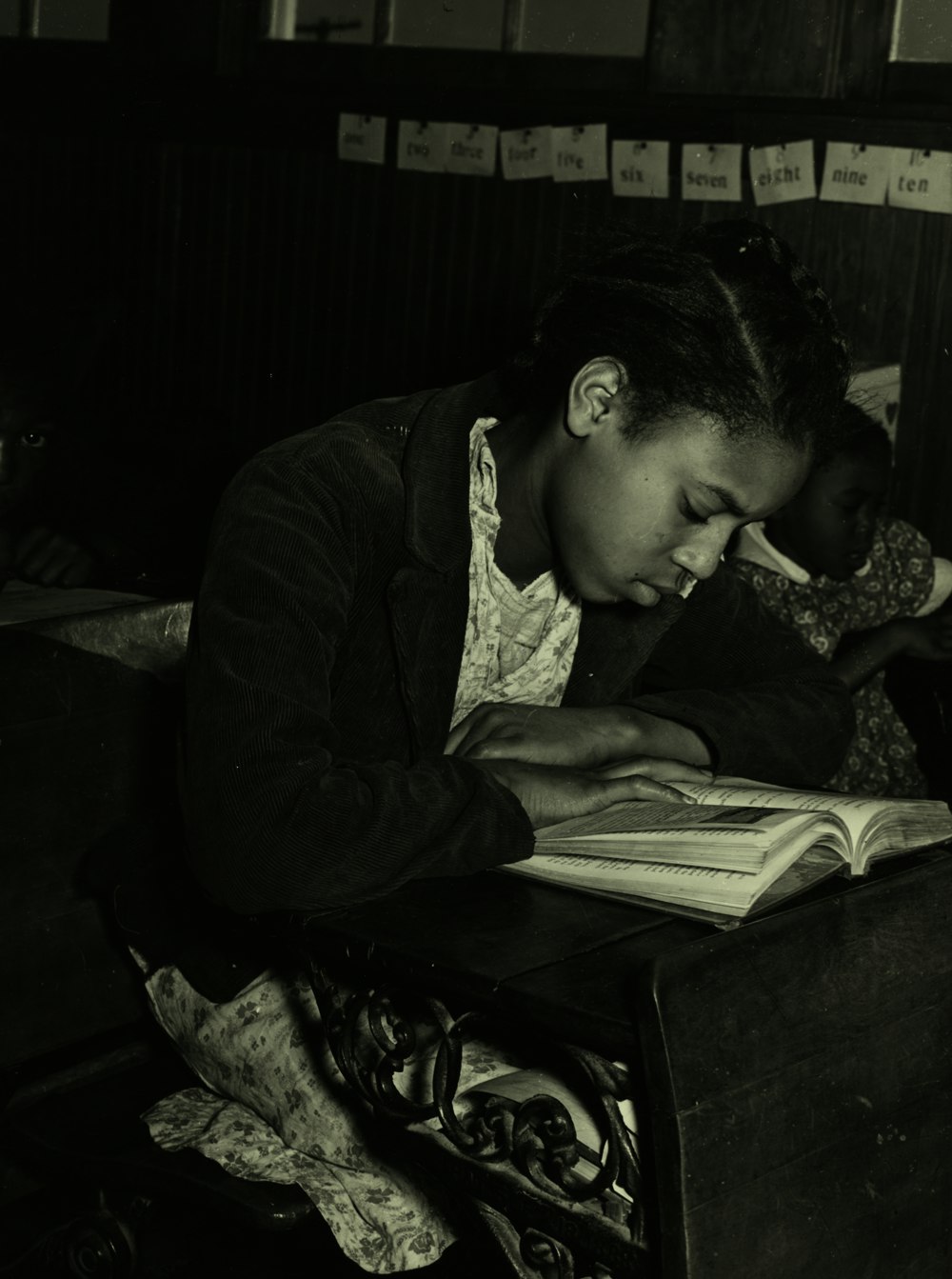 grayscale photography of unknown person reading indoors