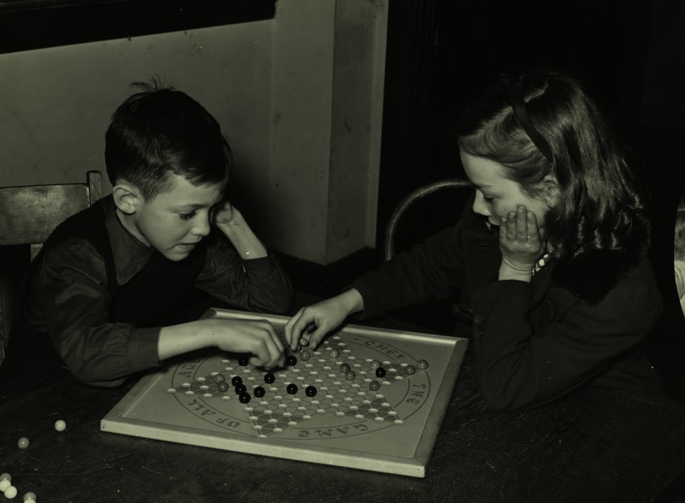 girl and boy playing chess board