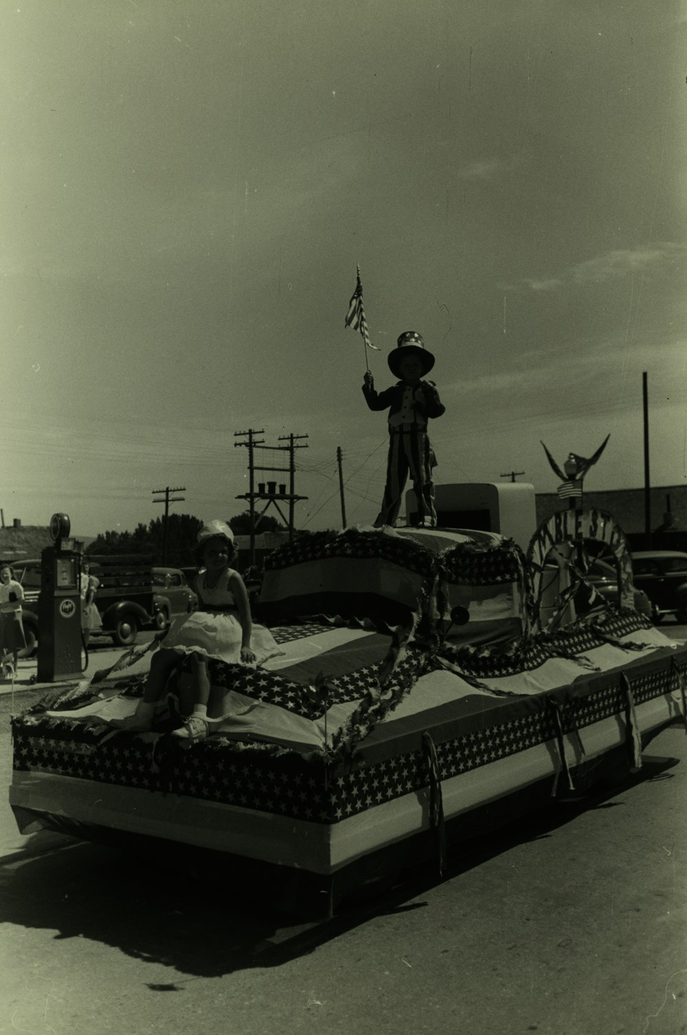 fotografia em escala de cinza de crianças montando um carro alegórico com tema dos EUA