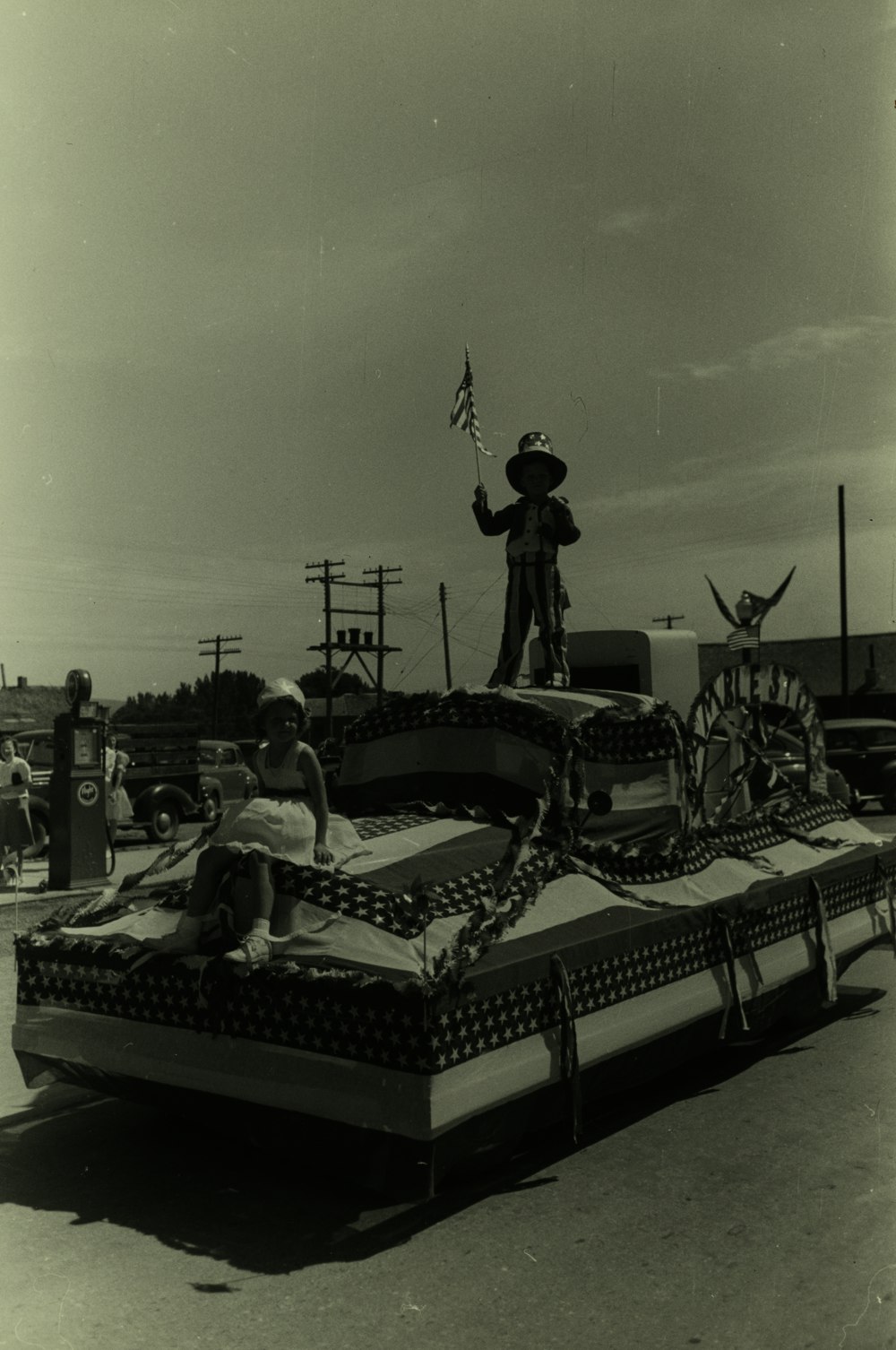 grayscale photography of children riding a USA-themed float