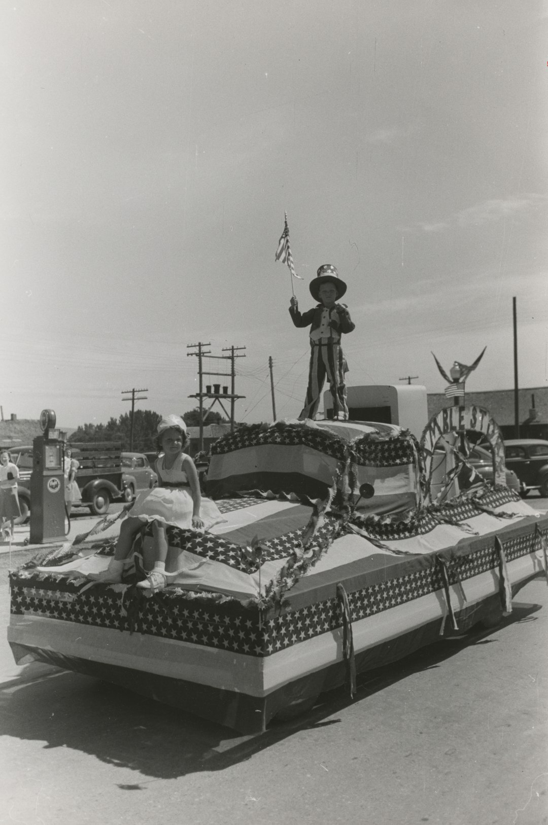 grayscale photography of children riding a USA-themed float