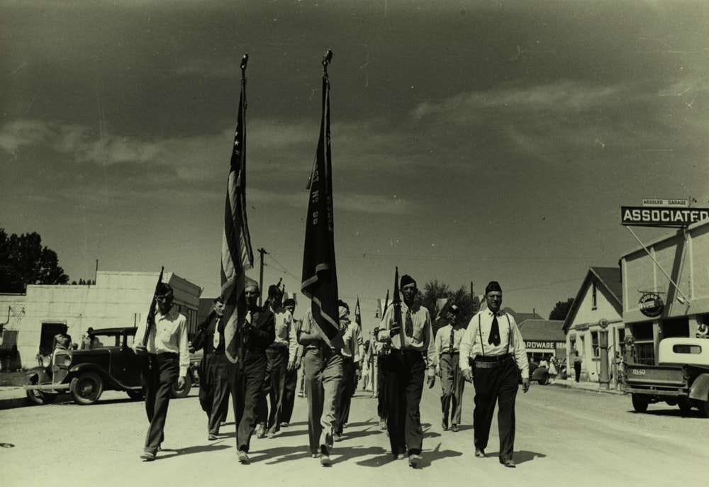uomini con la bandiera che marciano sulla strada