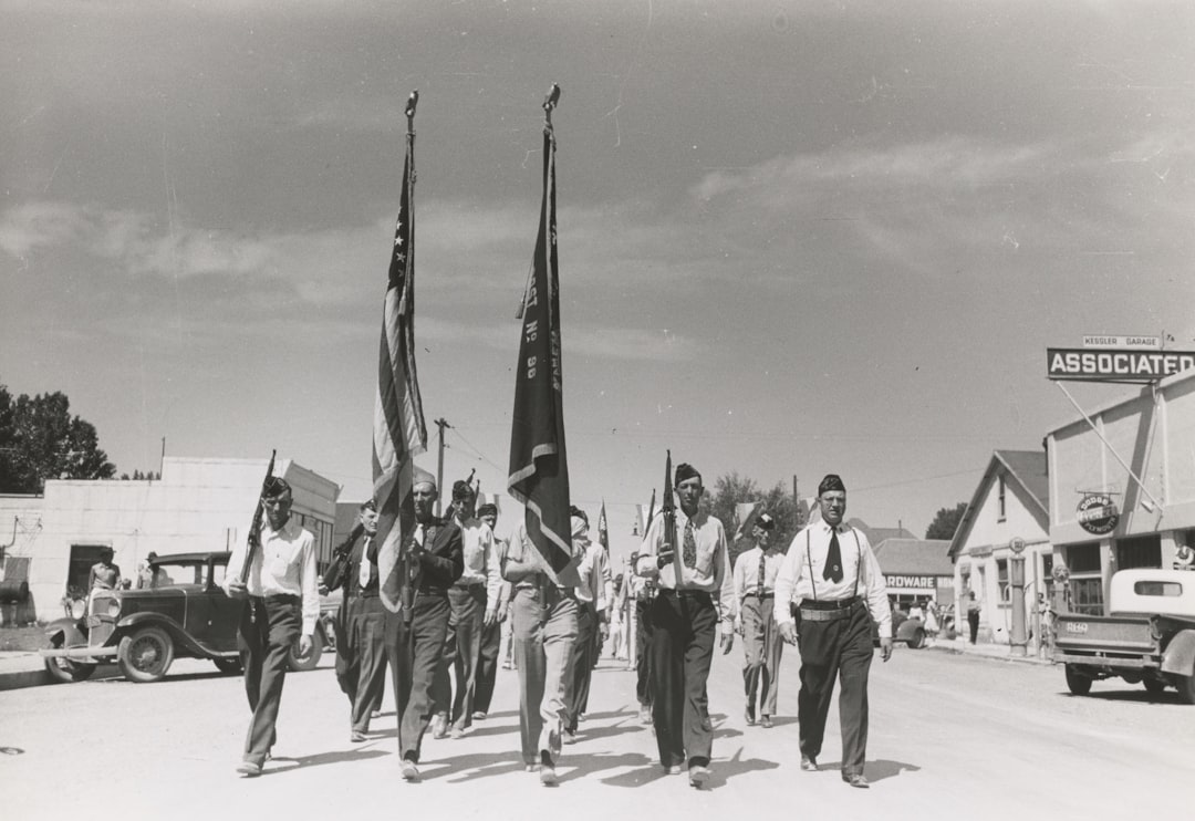 men with flag marching on road