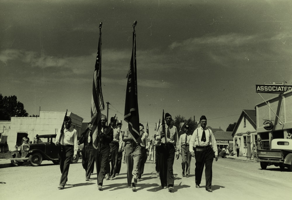 men with flag marching on road