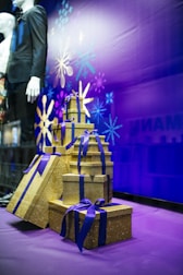 stack of gold gift boxes on purple floor