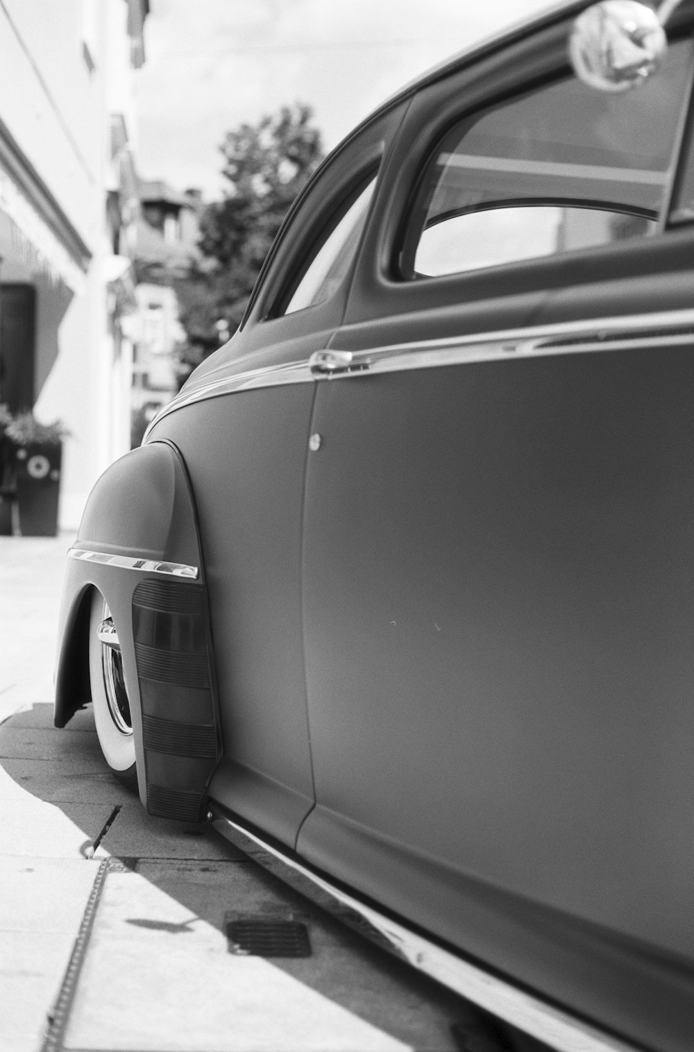 grayscale photo of car parked near building