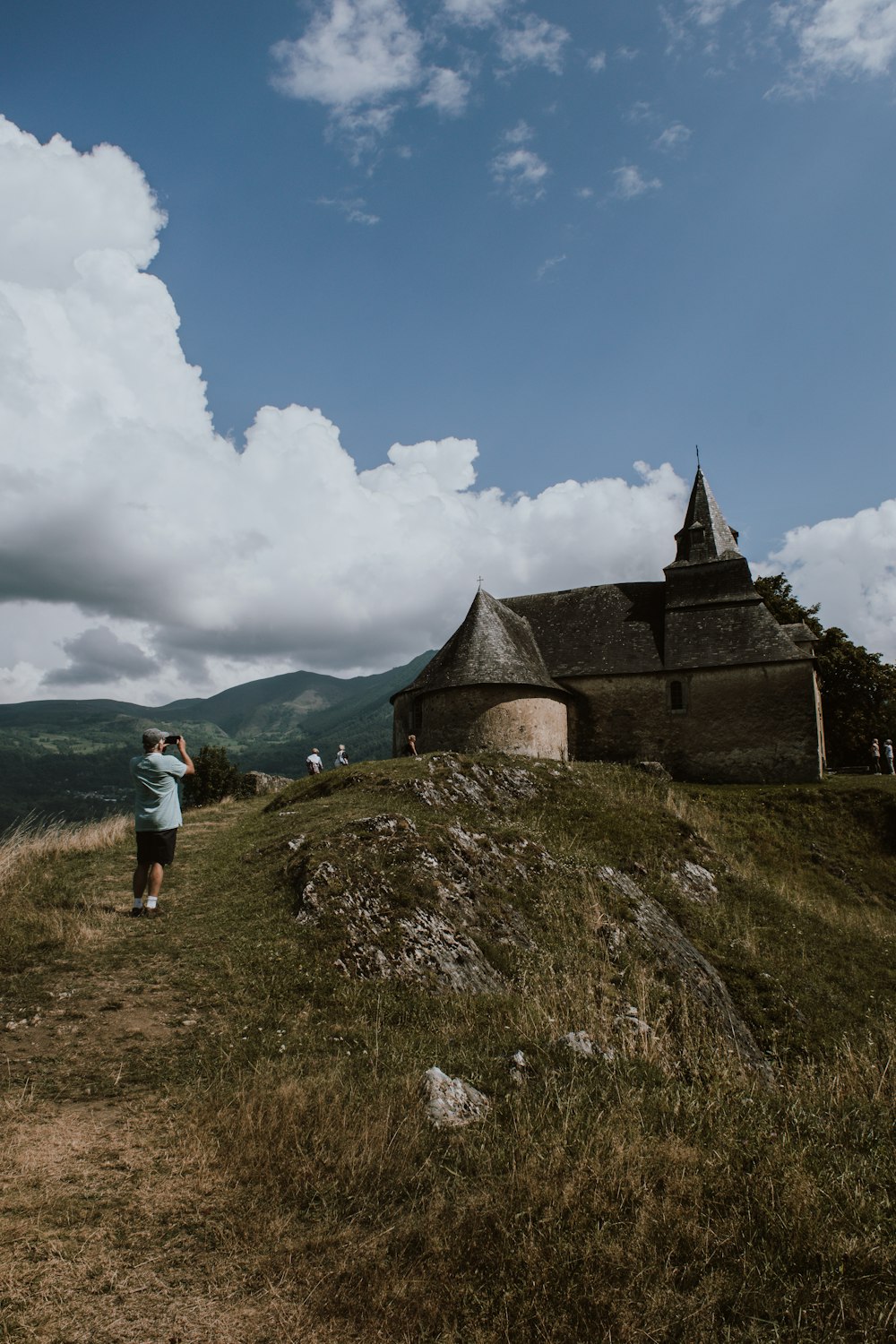 man standing near house on hill during daytime