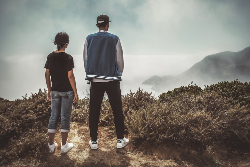 hombre y mujer de pie en la montaña durante el día