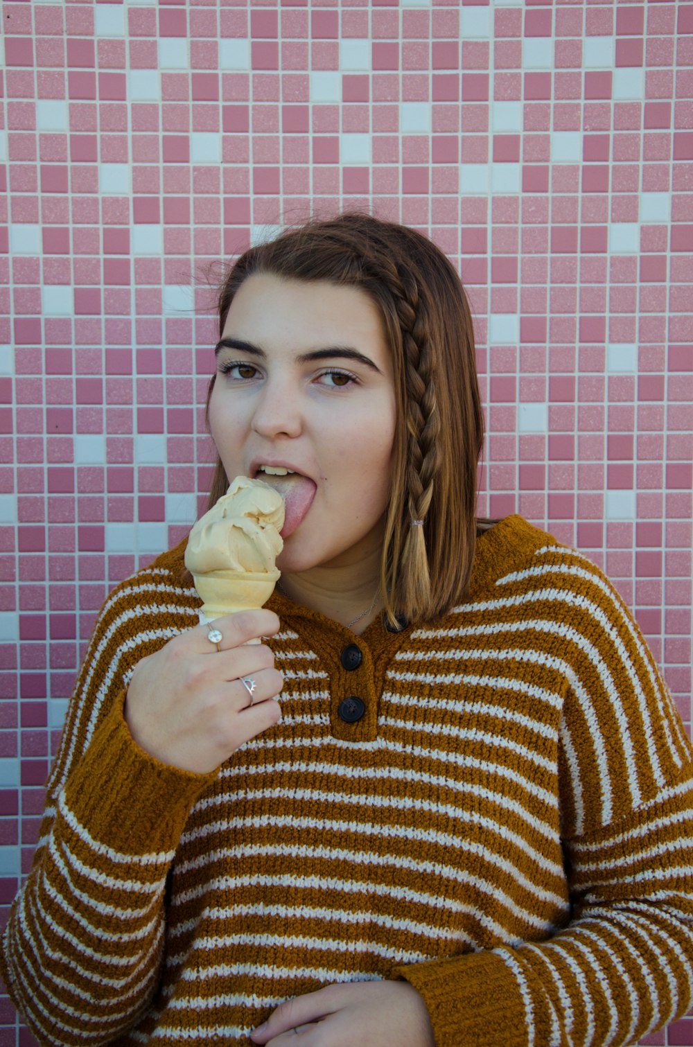 woman wearing brown and white floral sweater eating ice cream