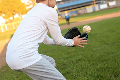 A professional baseball glove catching a fast-moving ball in mid-air.