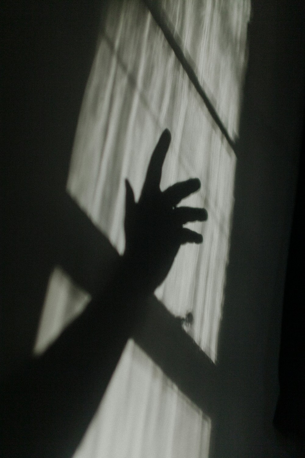 sombra de mano en ventana de vidrio