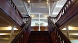 Elegant wooden stairs with decorative handrails in a warm setting.