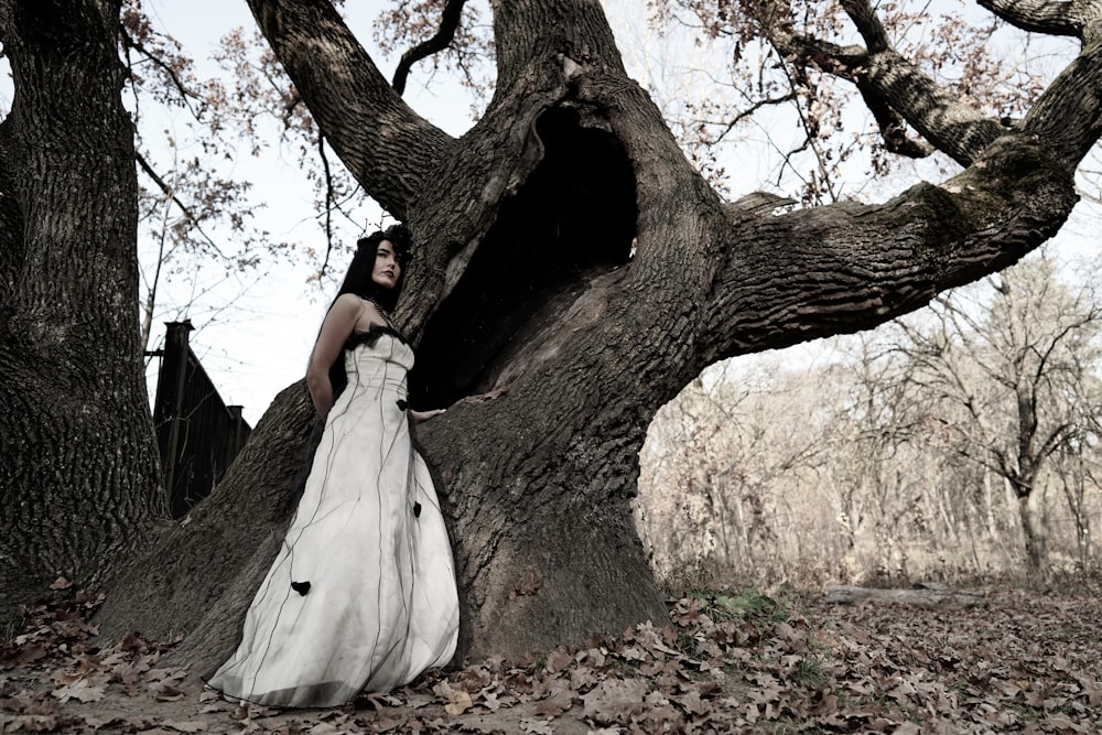 Mujer de pie junto al hueco del árbol