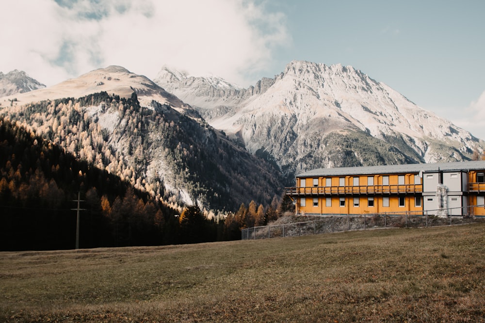 brown and gray building by a snowy mountain