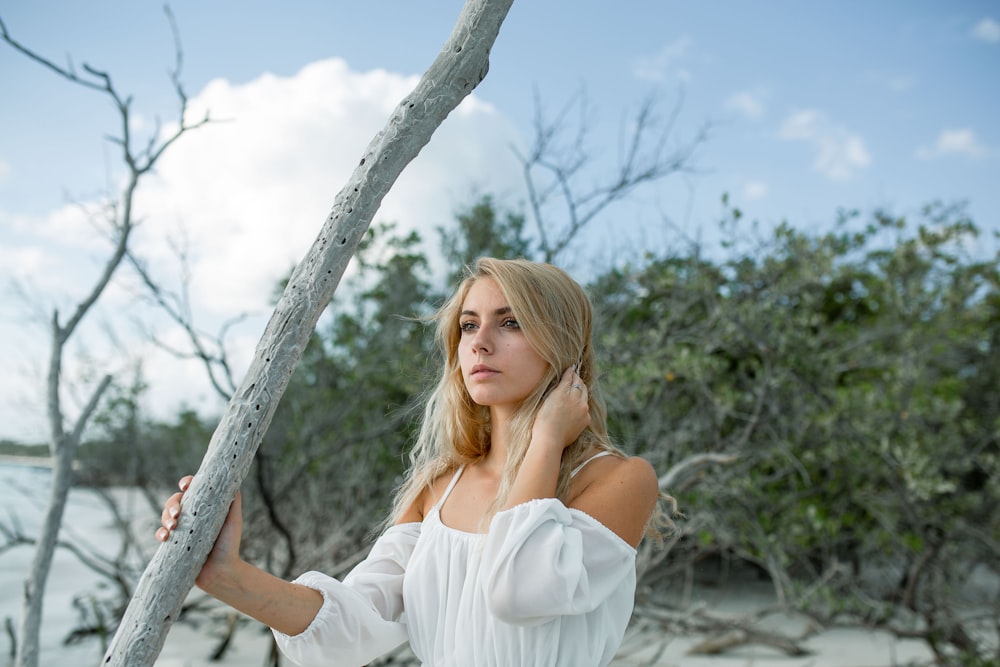 woman wearing white cold-shoulder long-sleeved shirt