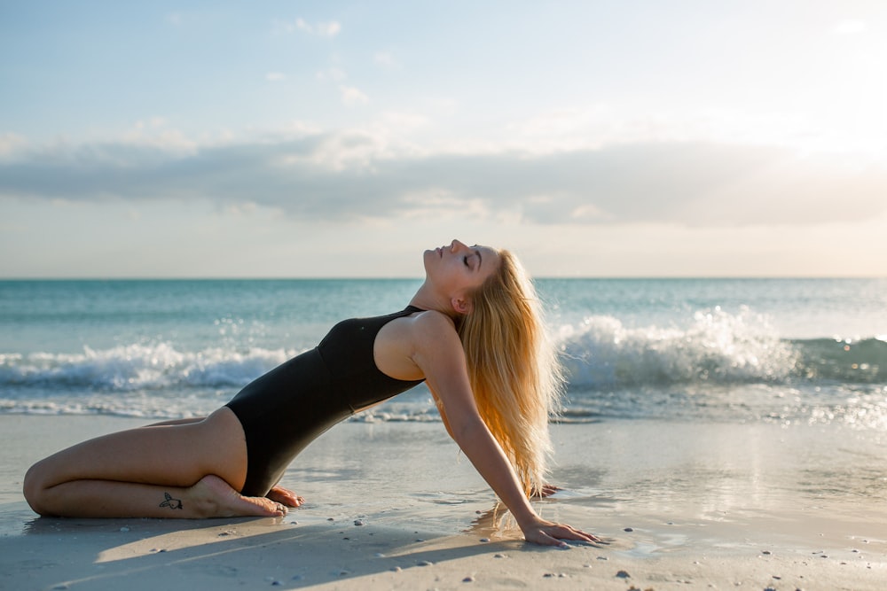 woman wearing black one-piece suit on seashore during daytime