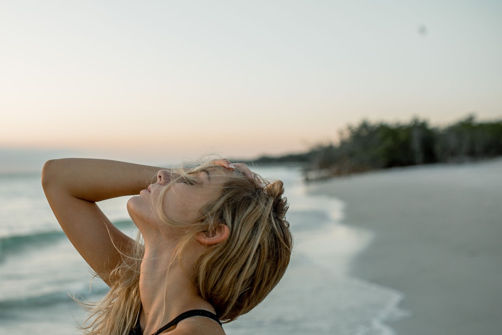 woman standing on seashore during daytime