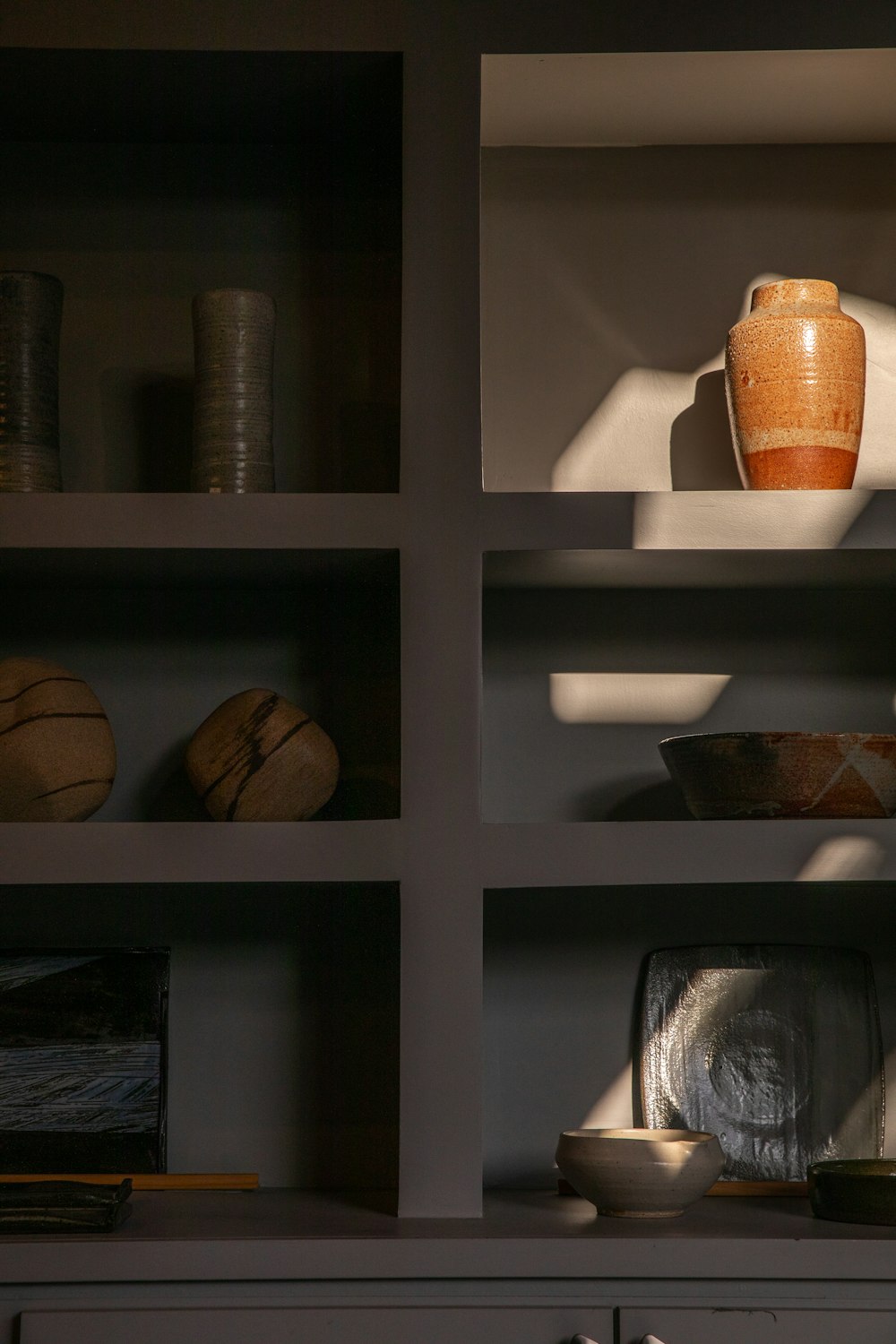 brown vase on white wooden shelf