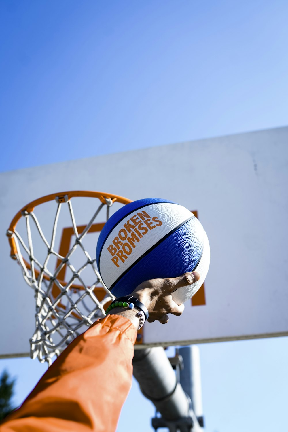 person holding basketball facing towards basketball hoop