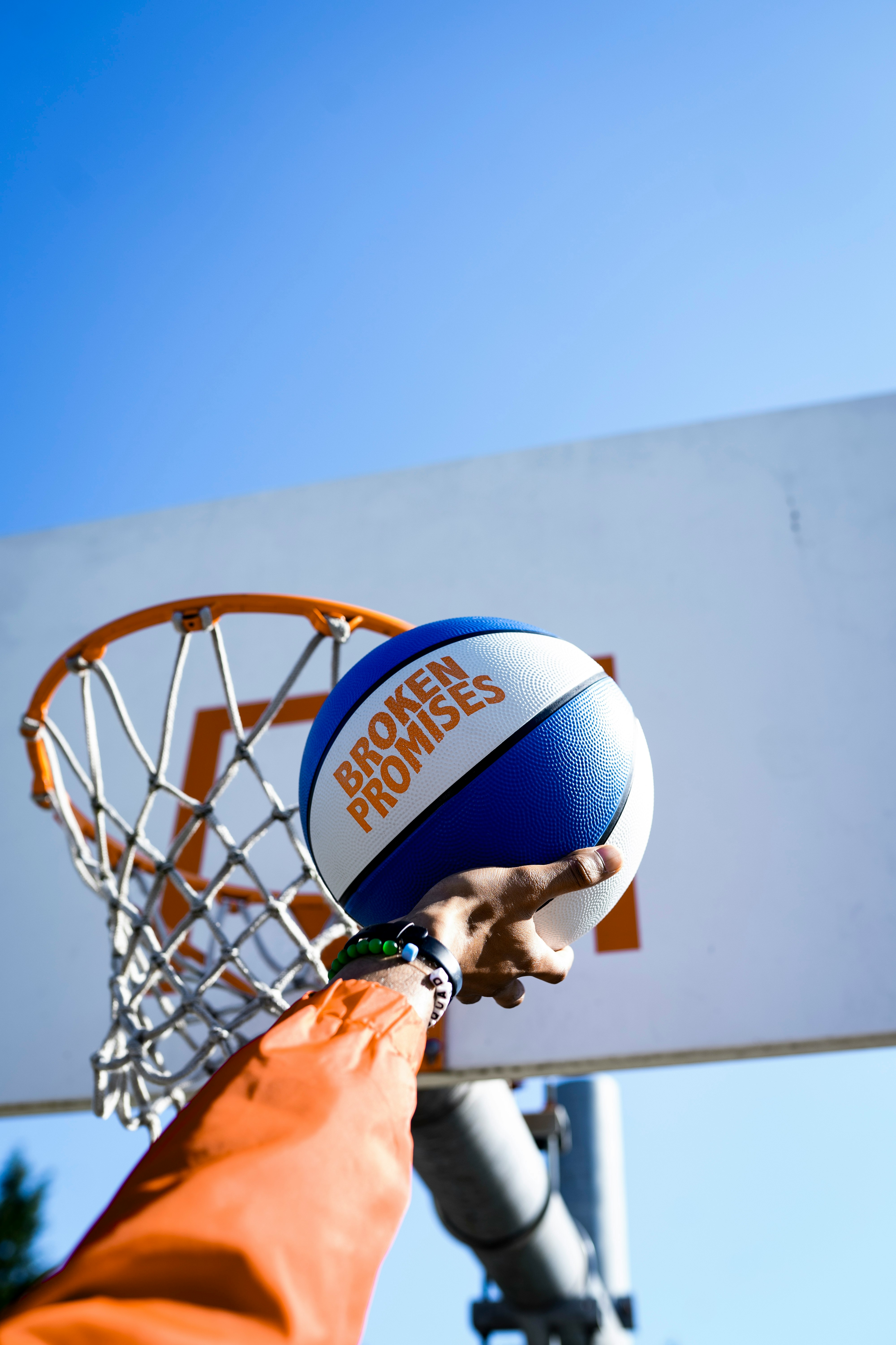 person holding basketball facing towards basketball hoop