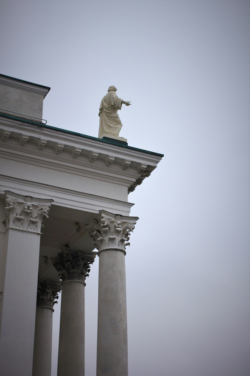 statue on white concrete building roof