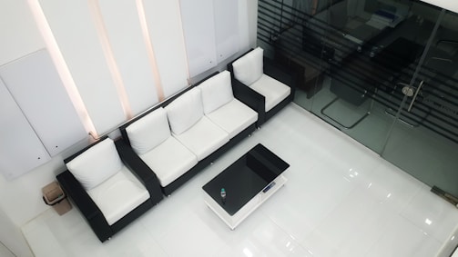 Minimalist architectural office reception area with clean white walls and modern furniture.