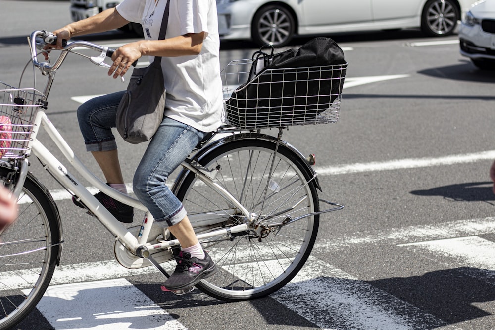 person drives bike with basket at the back with backpack