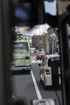 A busy city street with organized traffic flow and public transport vehicles in motion.