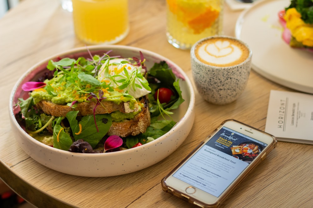 iPhone 7 doré à côté de la salade de légumes sur le bol