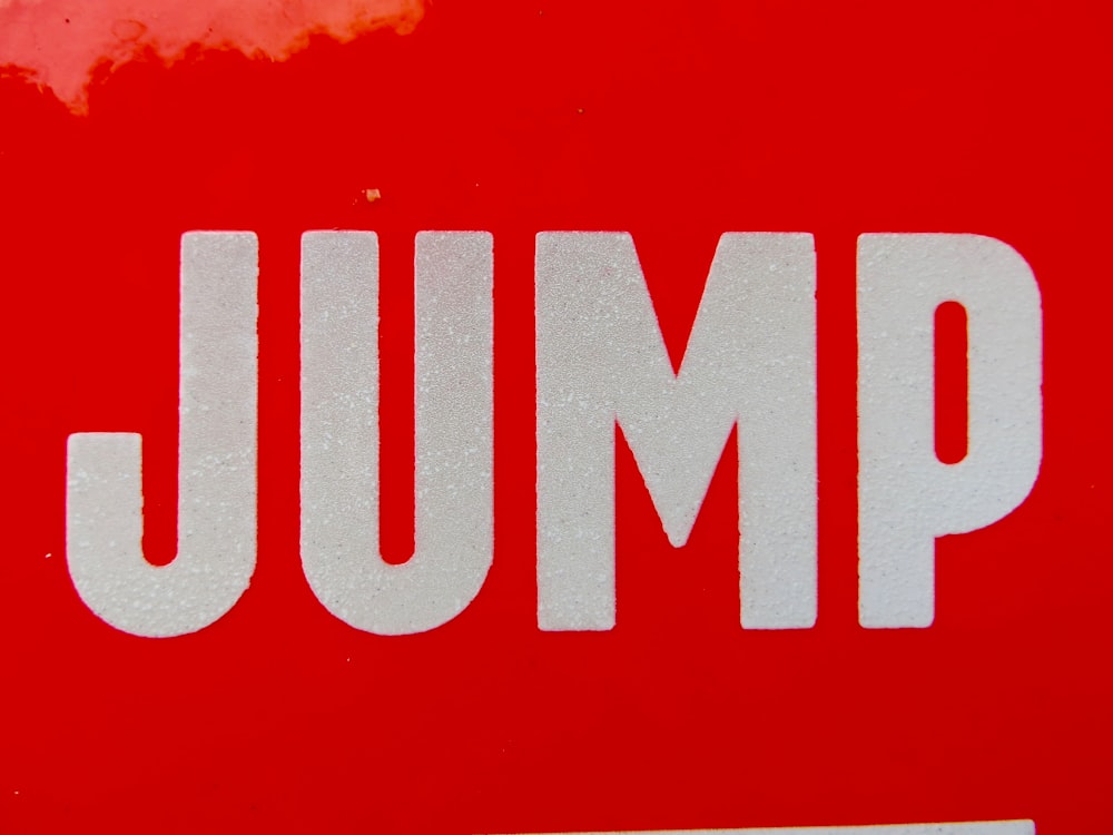a red and white sign that says jump
