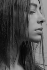 A grayscale side profile of a person with long hair, showcasing a contemplative expression.